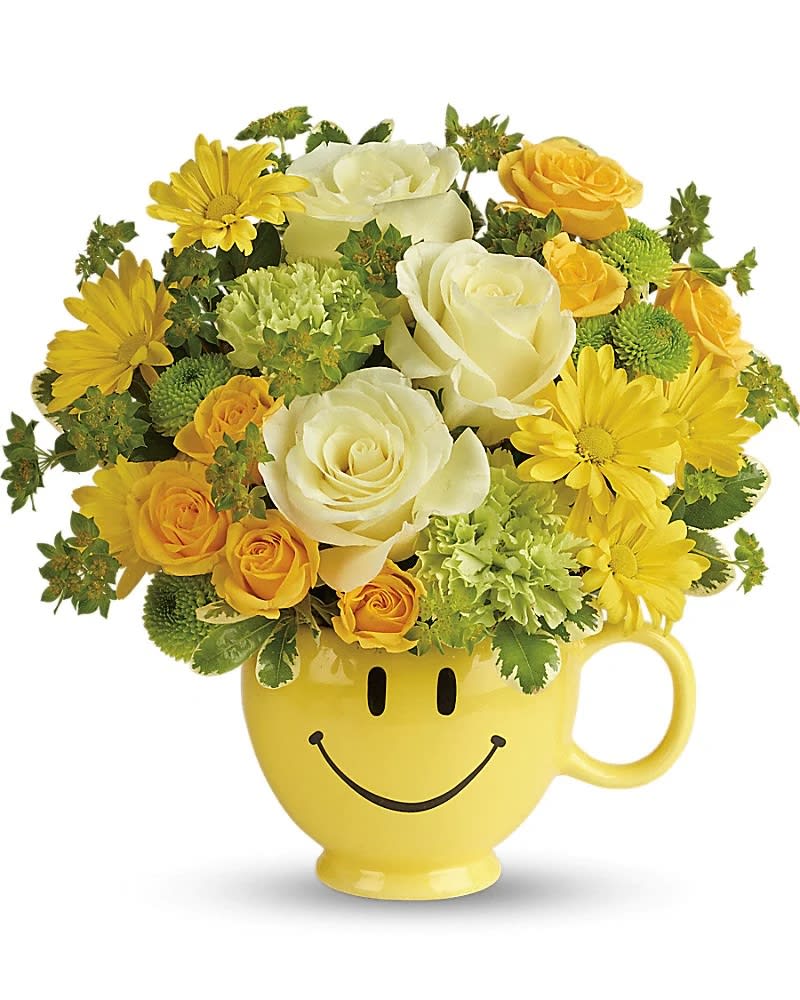 Make Me Smile Bouquet - Put a smile on their face - and in their heart - with this happy-as-can-be bouquet! Hand-delivered in a food-safe mug for years of satisfied sipping, this cheerful gift of roses and mums spreads happiness wherever it goes. This cheerful bouquet includes light yellow roses, yellow spray roses, green carnations, green button spray chrysanthemums, yellow daisy spray chrysanthemums, bupleurum, and variegated pittosporum. Delivered in a Be Happy mug.  