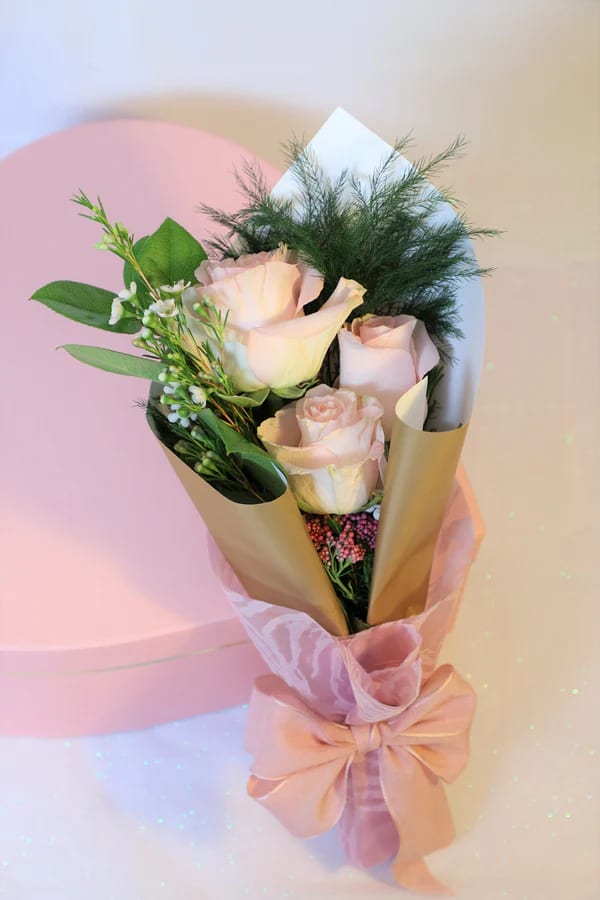 Puppy Love - A beautiful wrapped bouquet made with three rose and green filler bouquet wrapped in gold paper and pink rose lace. 