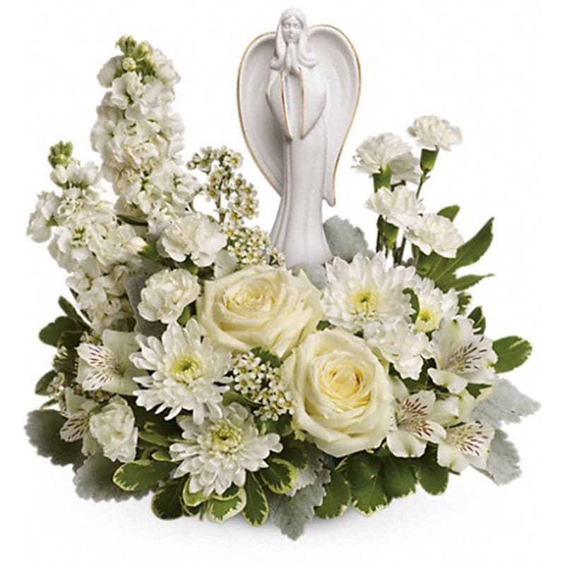 Guiding Light Bouquet [T274-2A] - Peaceful and majestic, a graceful angel rests amongst fragrant, snow white roses, alstroemeria and stock - a touching tribute to a bright life and your unending support.  White roses, white alstroemeria, white stock, white miniature carnations, white cushion spray chrysanthemums are arranged with white waxflower, dusty miller and variegated pittosporum. Delivered with an Angel of Grace keepsake.   Approximately 16 1/2&quot; W x 14&quot; H  Orientation: One-Sided  As Shown : T274-2A Deluxe : T274-2B Premium : T274-2C