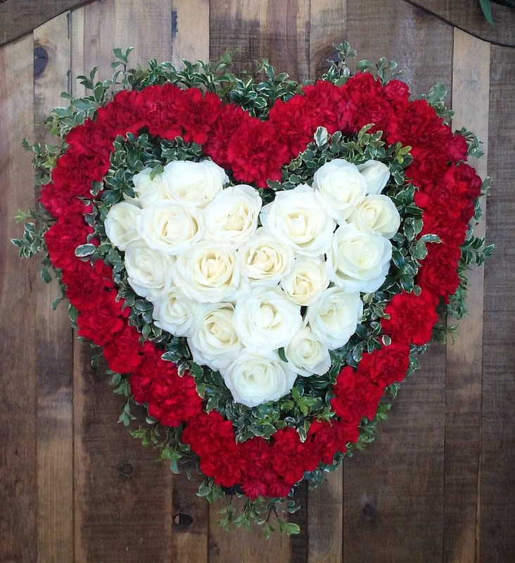 Heart Tribute - A lovely tribute for someone beloved. A heart accented with carnation and roses and fresh greenery. This arrangement will be dispalyed on an easel.