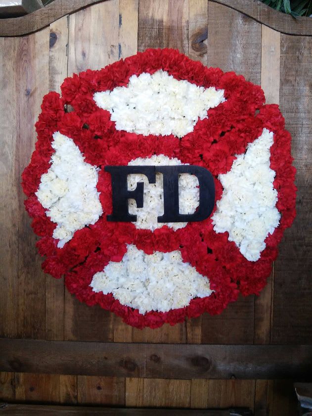 Maltese Cross - A lovely tribute for a firefighter, red and white flowers in a maltese cross. It measures approximately 24 by 24 inches. This piece requires 48 hours notice, please. 