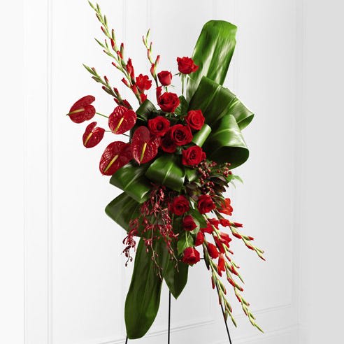 Modern Red Sympathy Easel Modern Red Sympathy Easel - A modern take on sympathy flowers. Ti leaf work adorns an assortment of red roses, anthuriums, gladiolas, and orchids in this exquisite design.