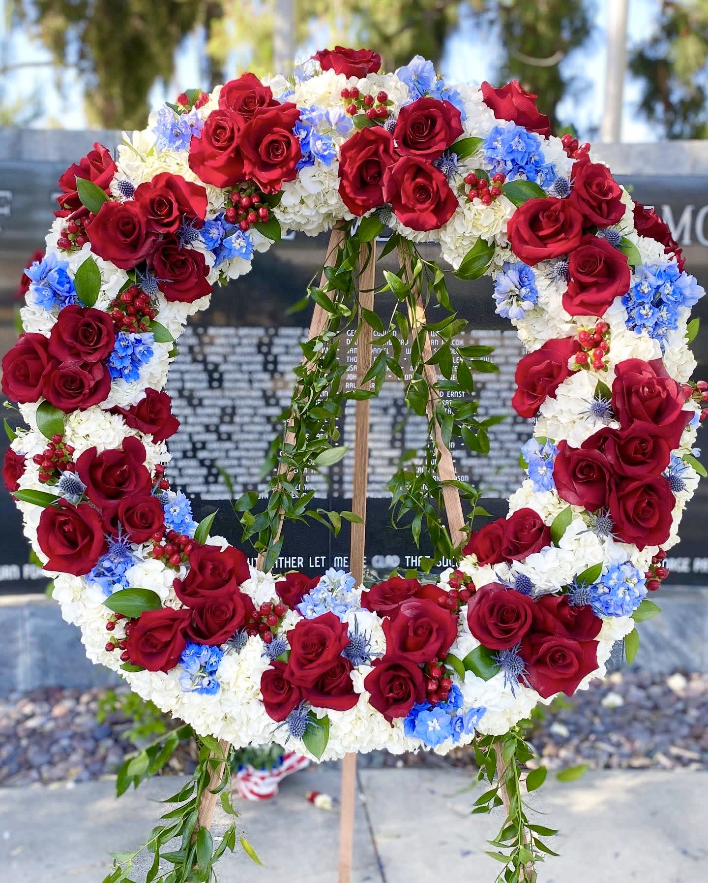 Red, White and Blue Wreath - An abundant wreath of hydrangeas, roses, and blue accent florals.  
