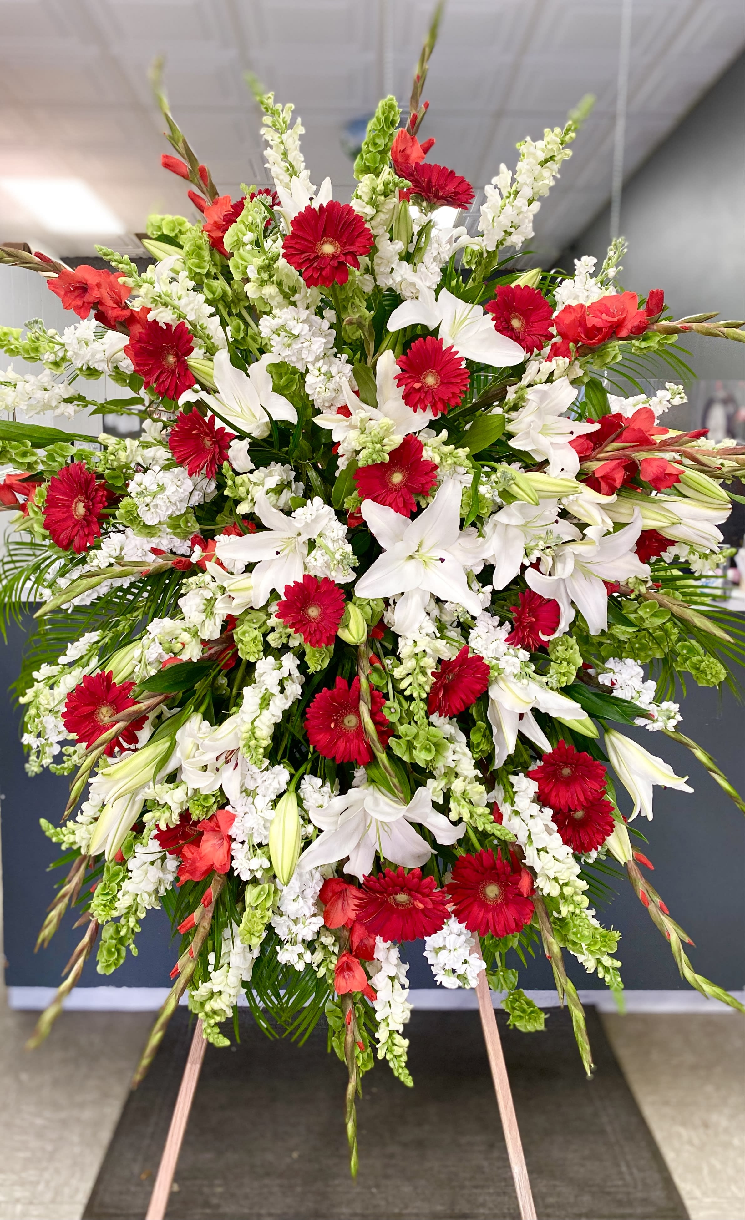 Standing Spray - Roses, Daisies, Lillies - Standing tall on an easel, this standing spray is full of Roses, Gerbera Daisies, Casablanca Lillies and other florals. Colors are customizable if stated in the comments. 