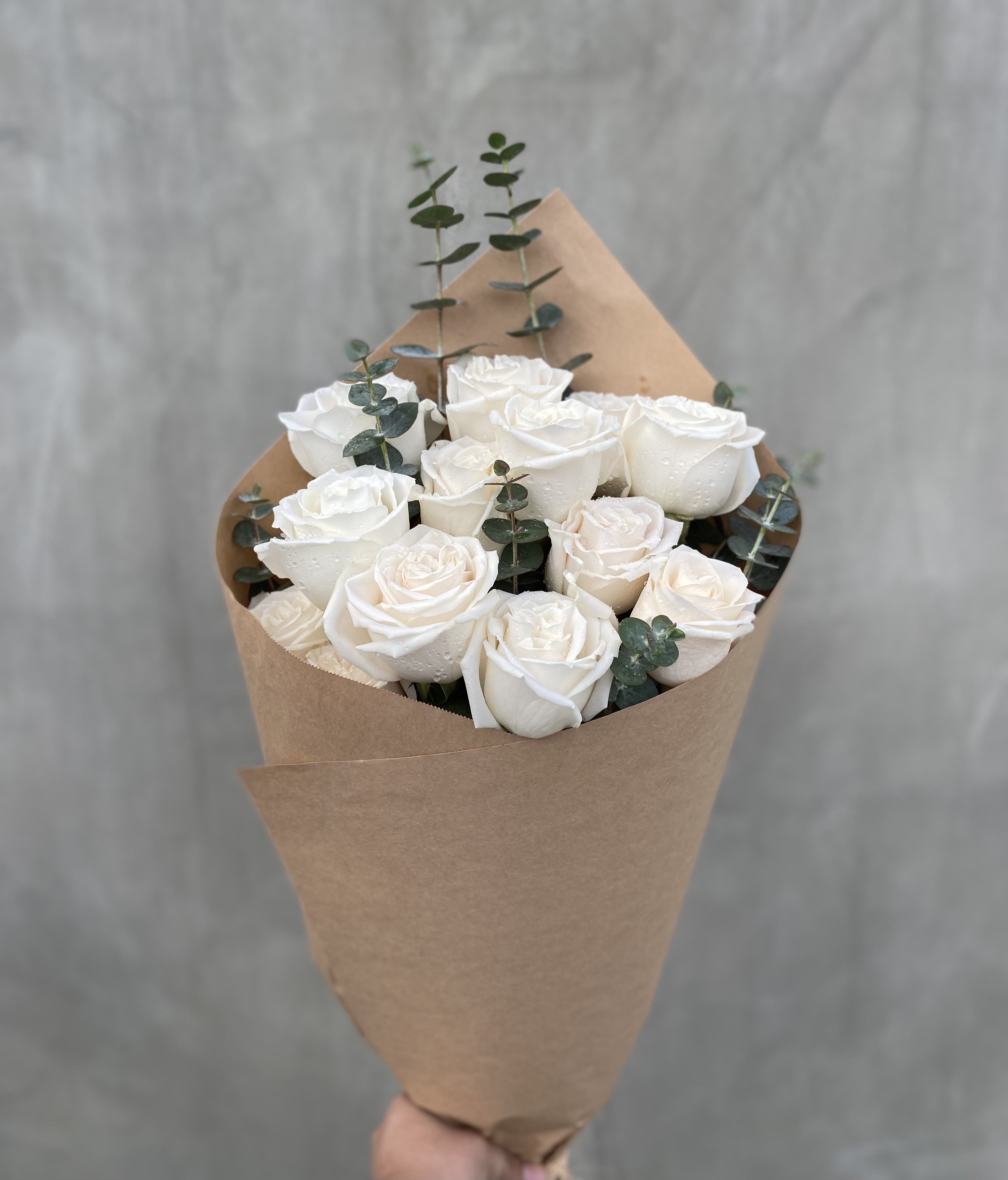 Pure Love Pure Love - One dozen white roses with eucalyptus wrapped in brown paper.