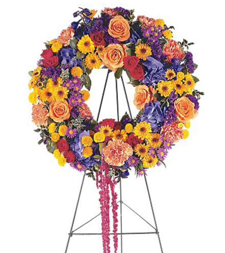 Celebration of Life Wreath - This beautiful wreath with its distinctive orange, yellow and blue flowers, will offer your regards in the warmest way. One wreath arrives on a easel filled with orange roses, yellow spray chrysanthemums, blue hydrangea, red amaranthus and purple asters. (Approximately 15&quot; D)