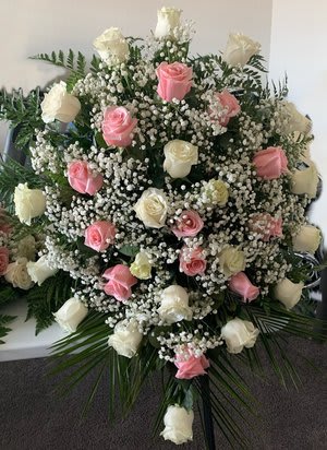 Sympathy Arrangement - Through tough times, flowers can emit comfort and peace. Show your sympathy with the composition of these thirty-six long-stem white and pink roses. For additional delicacy, Baby’s Breath flowers along with fresh greenery, are blended in. The bouquet sits in a clear vase.