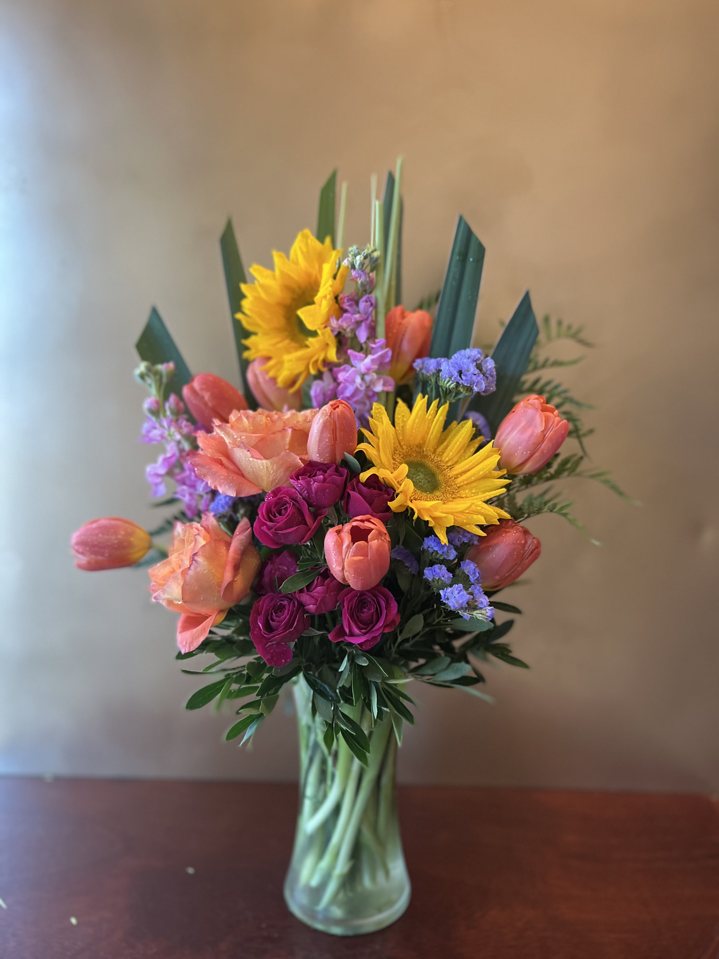 Spring Favorites - Roses and tulips and sunflowers - oh, my! All your spring favorites are here. The fun potted flower arrangement is a wonderful way to cheer up someone you love or brighten your own entryway. Also, a great housewarming gift!