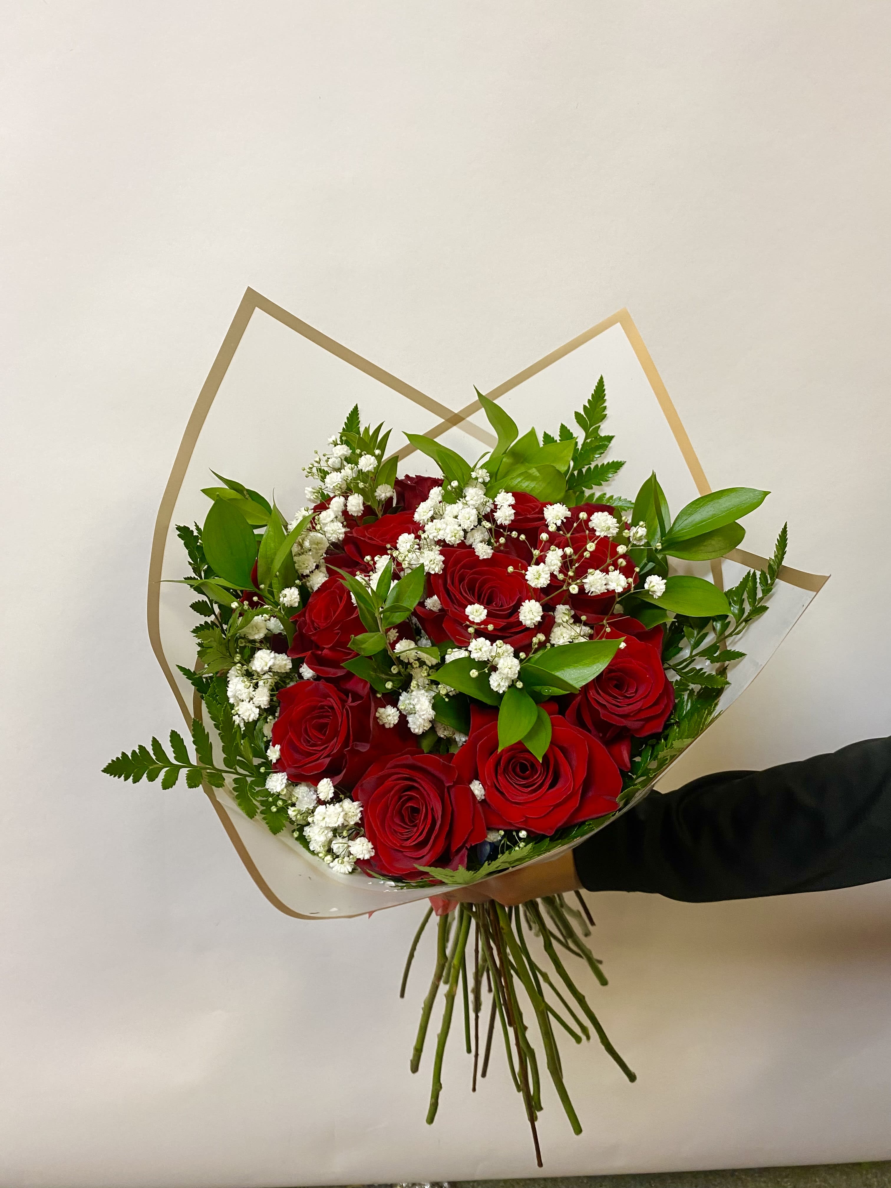Dozen Rose Wrap - A Dozen Roses Wrapped with Babies Breath and Greenery. Vase Not Included  Write Your Color Preference in the Special Instructions During Checkout. Color Options: Red, Hot Pink, Light Pink, Lavender, Orange, Yellow or White   