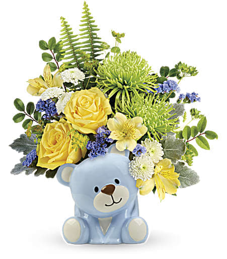 Teleflora's Joyful Blue Bear Bouquet Teleflora's Joyful Blue Bear Bouquet - Welcome the new bundle of love with this sunny yellow rose bouquet, charmingly presented in a sweet ceramic teddy bear. This joyful arrangement features yellow roses, yellow alstroemeria, green spider chrysanthemums, white button spray chrysanthemums, blue sinuata statice, bupleurum, dusty miller, huckleberry, and sword fern. Delivered in a baby blue Bundle of Love Bear. Approximately 12 1/2" W x 14 1/2" H