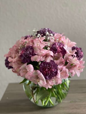Lovely Lavender - This exquisite piece is perfect for anniversaries or any special celebration. Express your care and gratitude with this lovely and delightful arrangement. The bouquet introduces a blend of striking pink alstroemerias flowers, vibrant purple carnations, and Baby’s Breath flowers. A round vase with transparent bubbles is used to display these lovely blooms.
