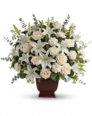 White Loving Lilies and Roses Bouquet - A simply beautiful way to show you care. By sending this elegant arrangement to the home of those in mourning, you are letting them know they are embraced in your thoughts. And in your heart.  Fresh flowers such as crème roses, white oriental lilies, carnations, eucalyptus and more are delivered in a lovely Noble Heritage urn.