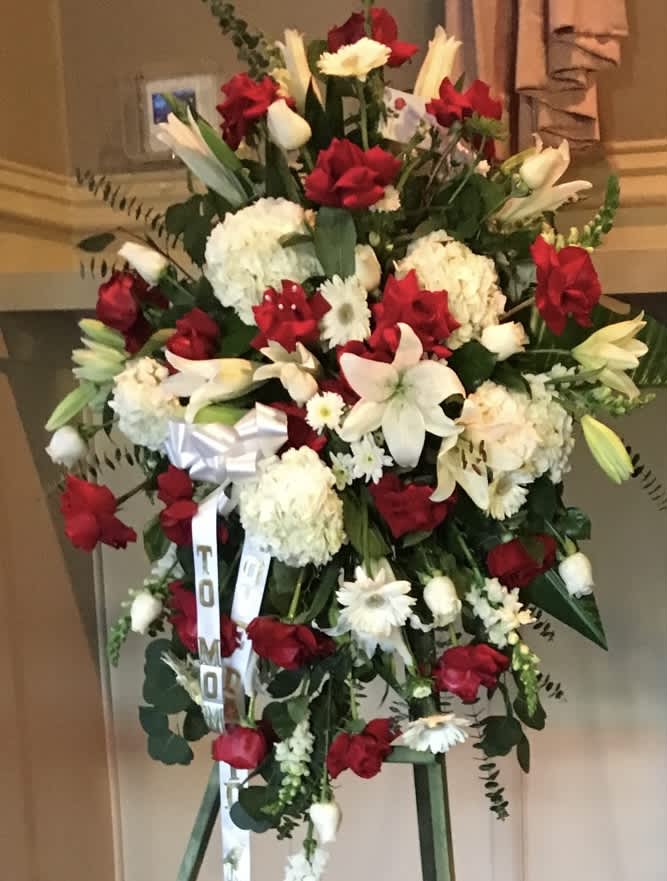SENDING OUR LOVE EASEL- RED AND WHITE - BEAUTIFUL BLOOMS. FEATURING RED ROSES AND WHITE LILIES. SITS ON A 5 FOOT EASEL.