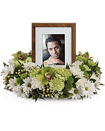 Garden Wreath - An exquisite round wreath with blooms inspired by the lasting impressions a loved one makes on our lives. Surround a treasured photograph, poem or other dear memento with sweet, green carnations, white and green chrysanthemums and the special beauty of green cymbidium orchids. This luxurious wreath includes flowers such as carnations, chrysanthemums, silky green cymbidium orchid blossoms and variegated greenery. Please note: Arrangement does not include picture frame.