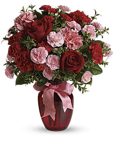 Dance With Me - A mix of carnations and roses in shades of red and light pink is delivered in a glass vase accented with pink satin ribbon.
