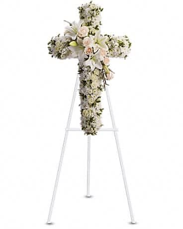 Divine Light - Your message of hope for eternal serenity is delivered ever so elegantly in this graceful cross. Your sincerity will be acknowledged by all who are present. CrÃ¨me roses, white spray roses, oriental lilies, stock, leptosporum, cushion and button spray chrysanthemums create a cross that is a beautiful way to honor a loved one.