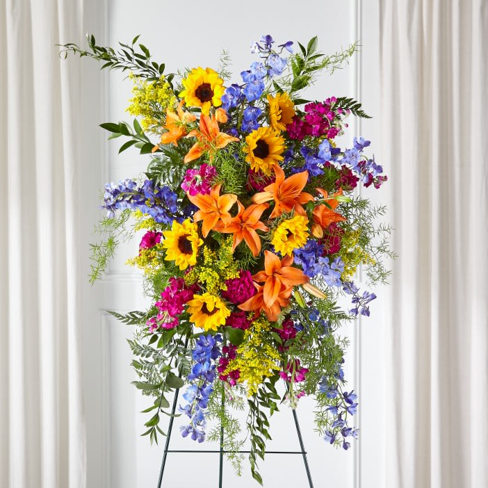 Sunlit Memories™ Standing Spray  - Our Sunlit Memories™ Standing Spray is crafted with a mix of fuchsia, deep blue, hot pink and orange florals to celebrate their radiant life. This vibrant display combines bright shades with stunning texture while sharing thoughtful sentiments and comfort to loved ones.    Details:  o Spray is approximately 36&quot;Hx 25&quot;W 