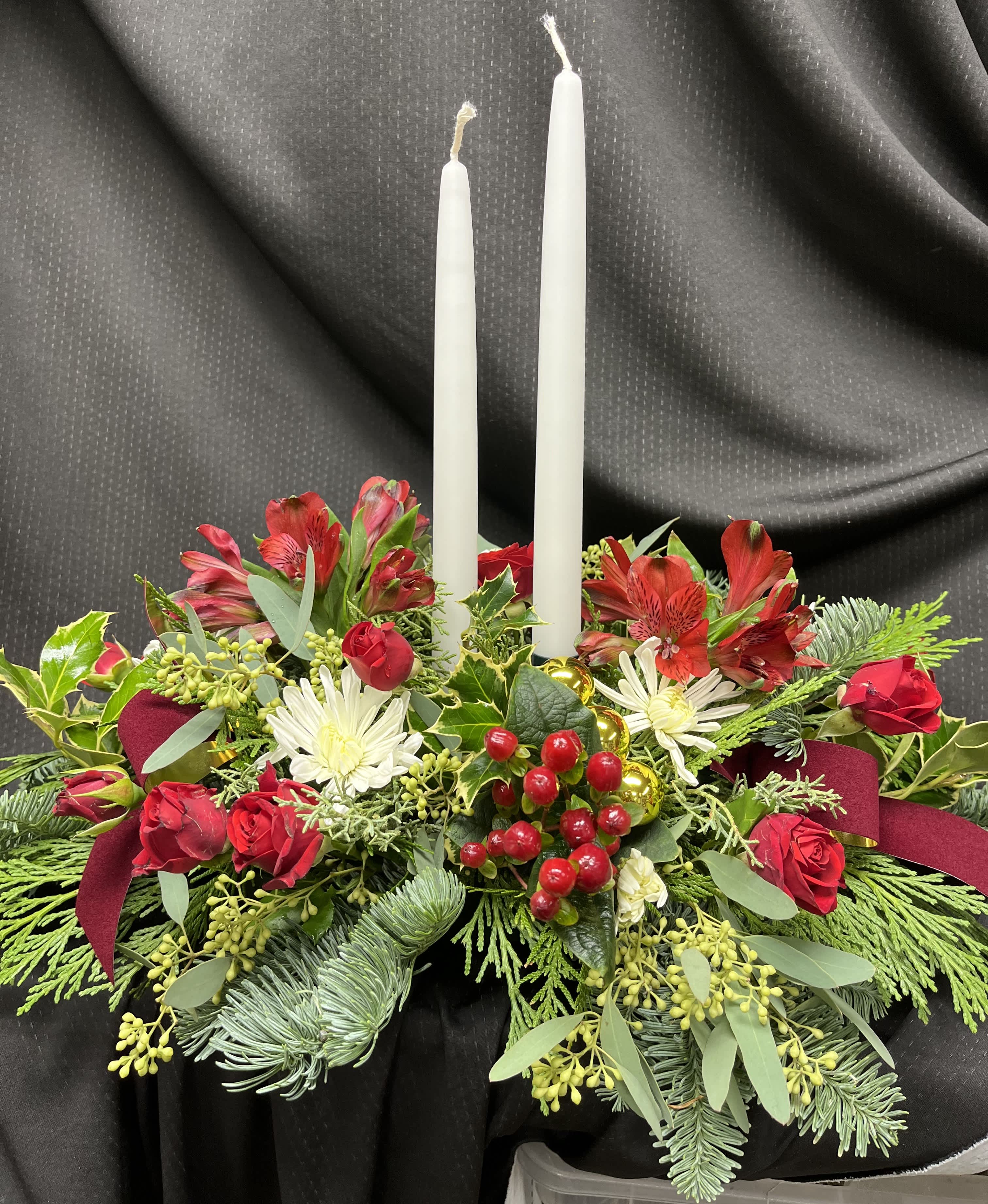 Thanksgiving Centerpiece - Thanksgiving centerpiece made up with candles, seasonal greens, spray roses, and alstroemeria.