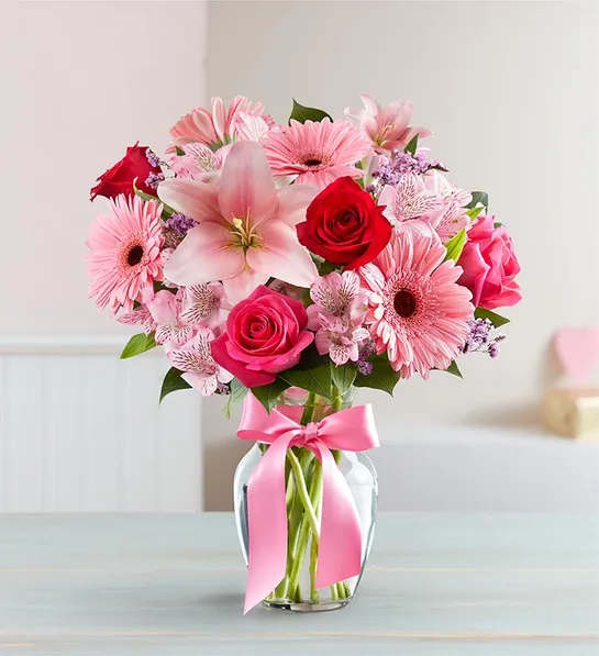 Fields of Europe Romance - Inspired by the rich beauty of the European countryside, our romantic bouquet reveals all the feelings you have in your heart. Fresh-picked pink &amp; red blooms are on display inside a glass vase finished with ribbon, creating a timeless gift for someone you love.  All-around arrangement with red and hot pink roses, pink Asiatic lilies, Peruvian lilies (alstroemeria), Gerbera daisies and limonium; accented with assorted greenery Artistically designed in a clear glass vase accented with a pink satin ribbon