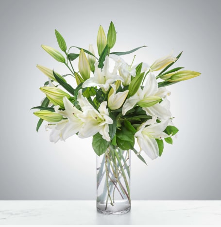 Peaceful Evening by BloomNation™ - White lilies stand tall and beautiful. Send an impactful gift to somebody whether it be for saying I am sorry or celebrating the new year. This arrangement instantly elevates any room and fills the space with that distinct sweet-smelling lily perfume.  1st Image: Standard 2nd Image: Premium