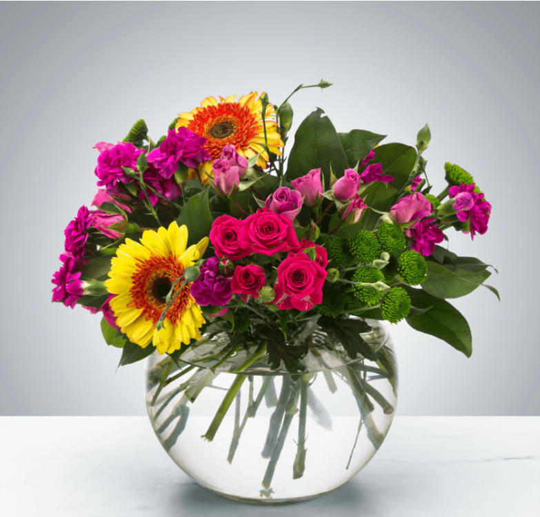 Meadow Magic by BloomNation™ Meadow Magic by BloomNation™ - A bright bubble arrangement featuring button mums, gerbera daisies, and spray roses, this arrangement makes a lovely thank you or just because gift. Approximate Dimensions: 12''D x 12''H