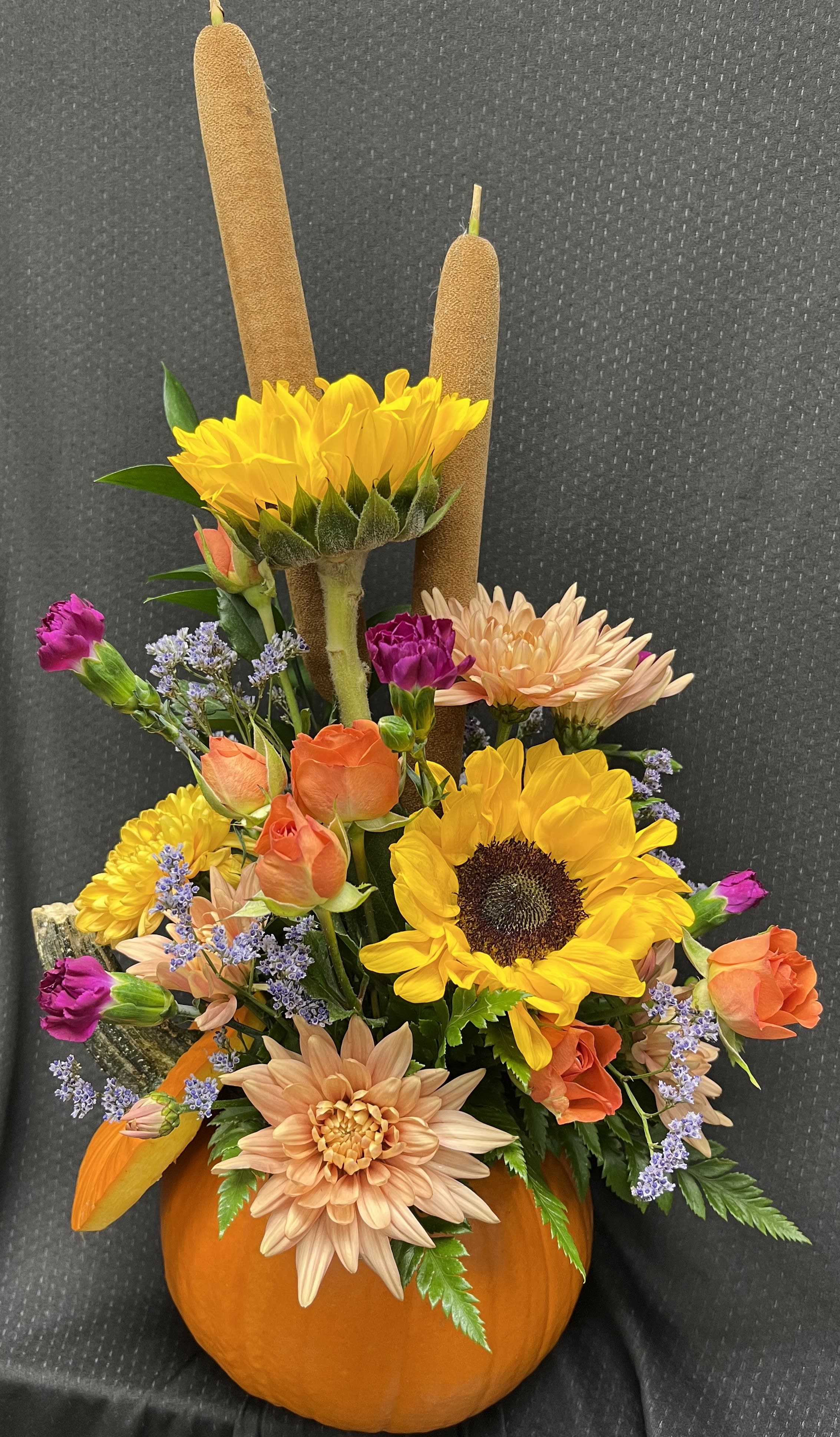 Pumpkin Time - Sunflowers and other seasonal flowers arranged in a unique pumpkin container!