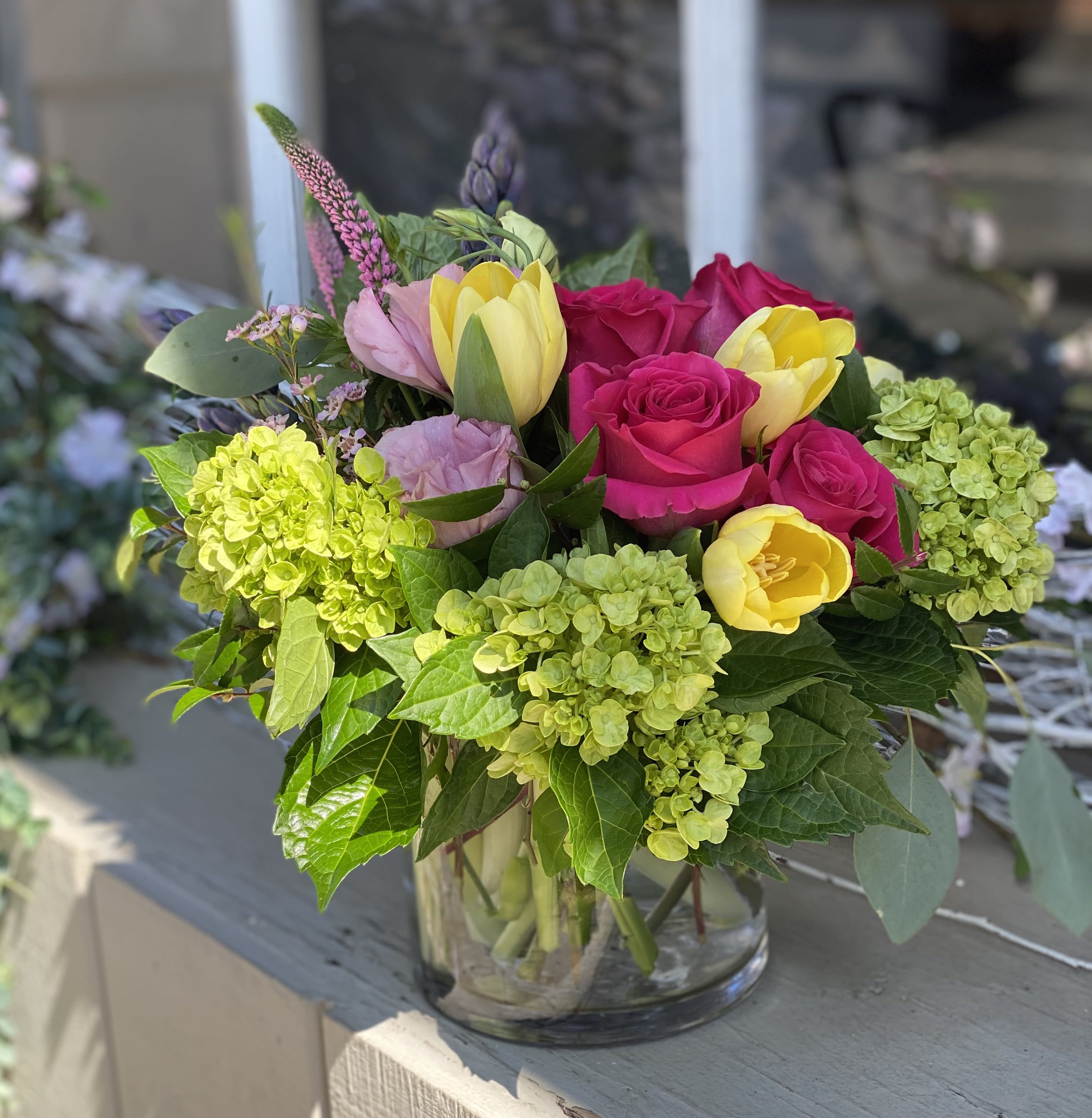 Good Vibes  - Send the message of cheer and love with this arrangement of fresh-cut flowers in bright colors of yellow, magenta pink and lime green. Roses, Tulips and Hydrangea are always a best selling combination sure to delight someone you care about.   Arrangement is approximately 10&quot; high x 10&quot; wide.  COVID NOTICE: Due to an international shortage of flowers and vases and floral supply chain issues, it may be necessary to substitute similar flowers and the vase used in this design. We always strive to create a design as close as possible to the design shown. If you have any questions regarding these changes, please call and talk to a team member before placing your order, (703) 779-3530. 