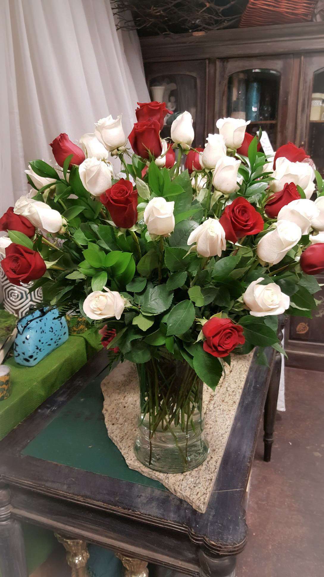 Luxury Roses - A large display of white and red roses arranged in a clear vase 