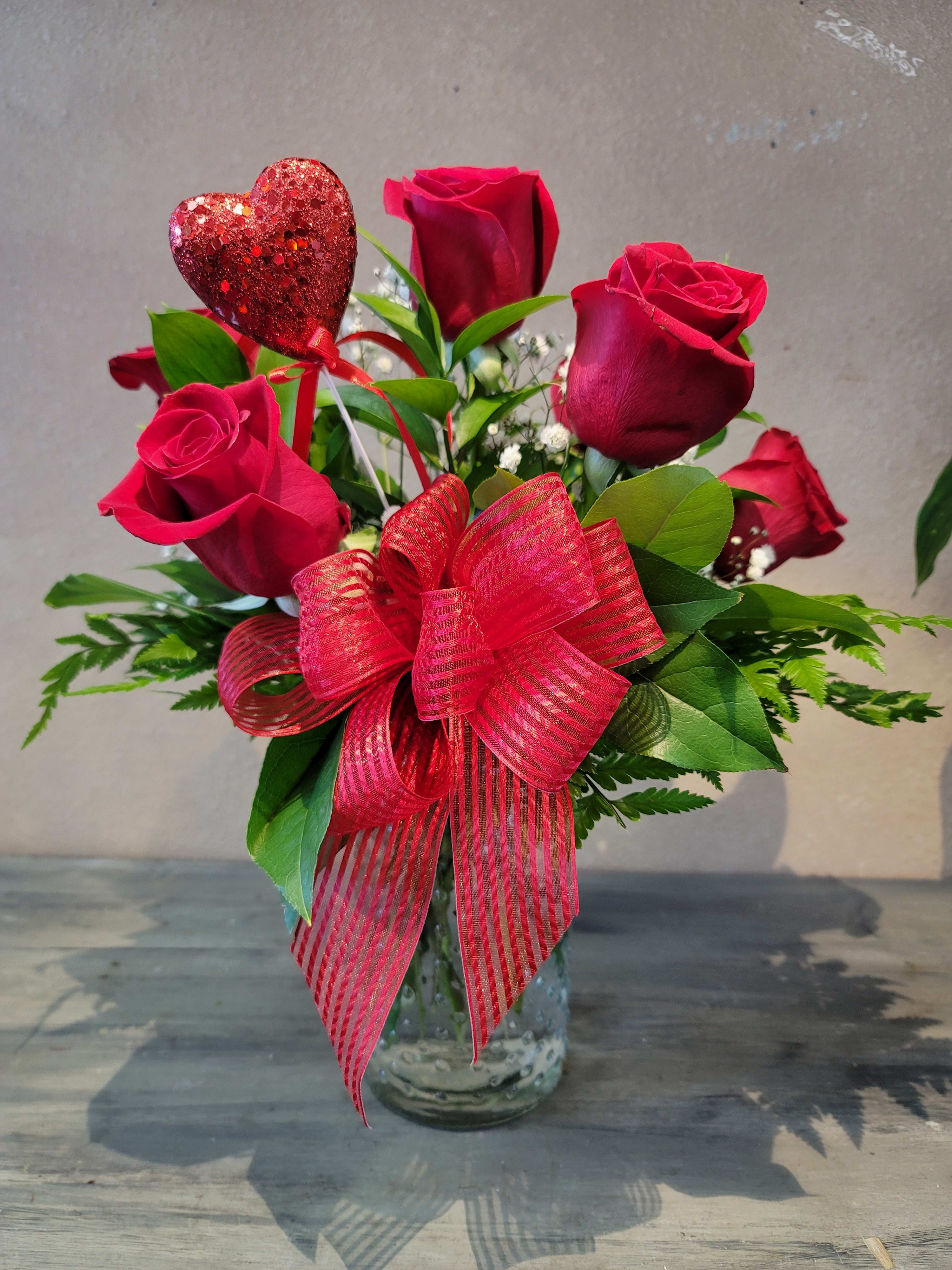 Half Dozen Red Roses - A cute arrangement of six red roses paired with nice greenery and filler flower.   Please Note: Exact vase may vary based on availability. Filler flower may vary. For any specific requests or if you want a different color rose, please call us ahead of placing your order.