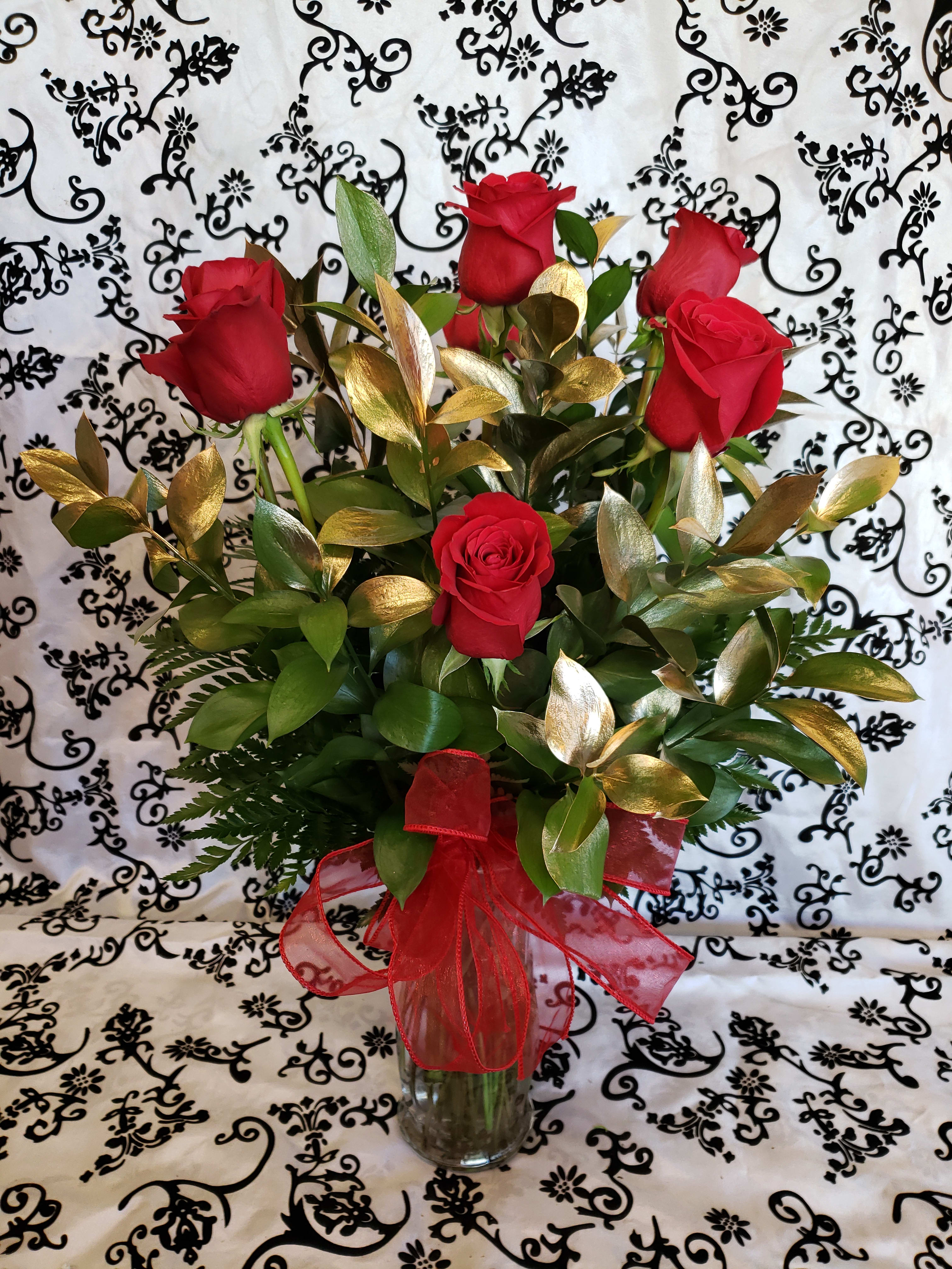 6 RED ROSES MODERN STYLE 6 RED ROSES MODERN STYLE - 6 RED ROSES WITH GOLD RUSCUS LEAVES IN A VASE NOTE IF YOU WANT A DIFFERENT COLOR OF ROSES PLEASE ADD THIS UNDER SPECIAL INSTRUCTIONS AND WE WILL SUBSTITUTE TO THE COLOR OF YOUR CHOICE IF THIS COLOR IS AVAILABLE. THANKS