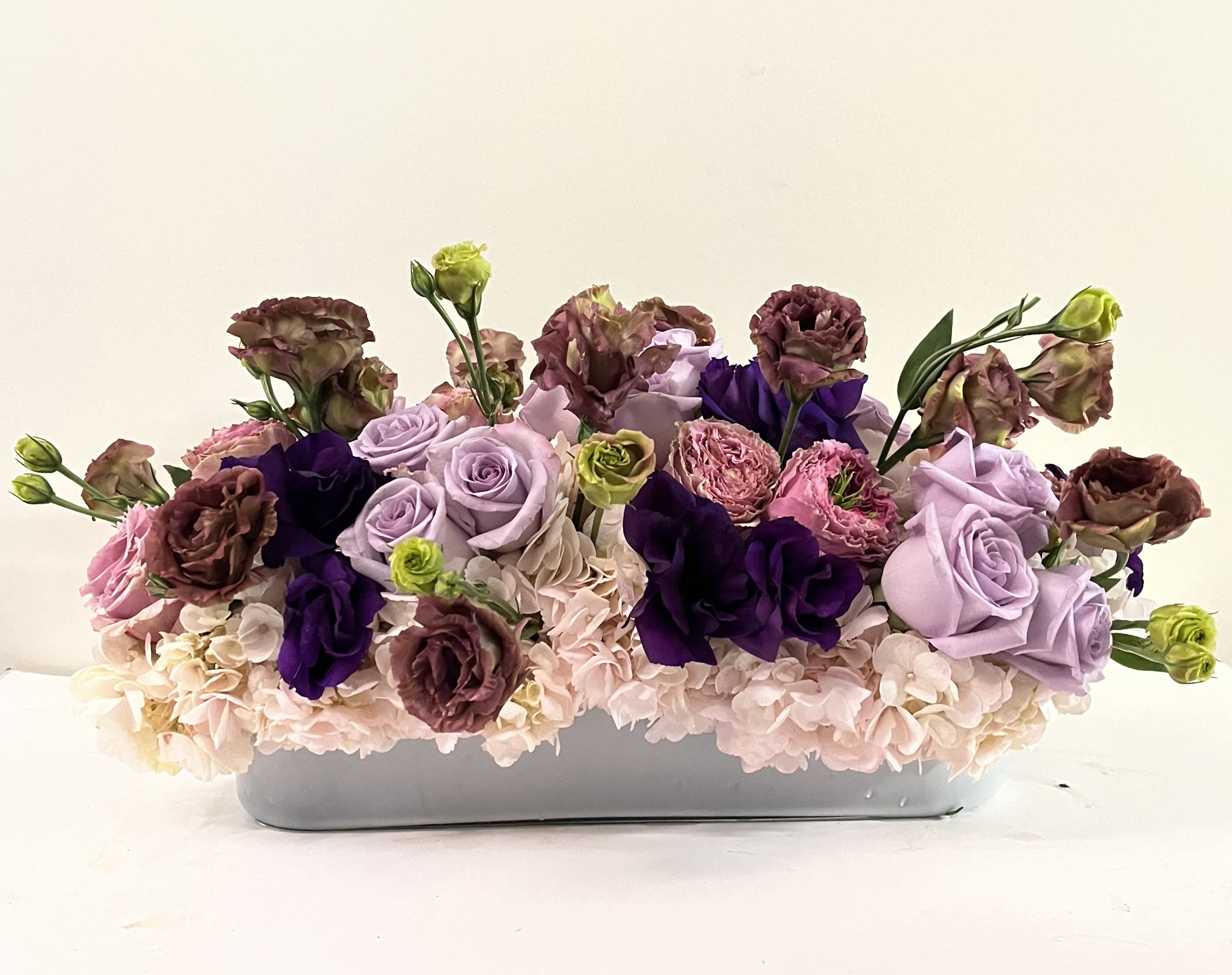 Soft &amp; Gentle #EF214 - Combination of amazing colors put together in a white low &amp; long glass vase with Soft Pink or White Hydrangea, Lavander Roses, Brown  &amp; Purple Lishanth's, medium Pink Roses.  A Very delicate Arrangement appropriate for any occasion   