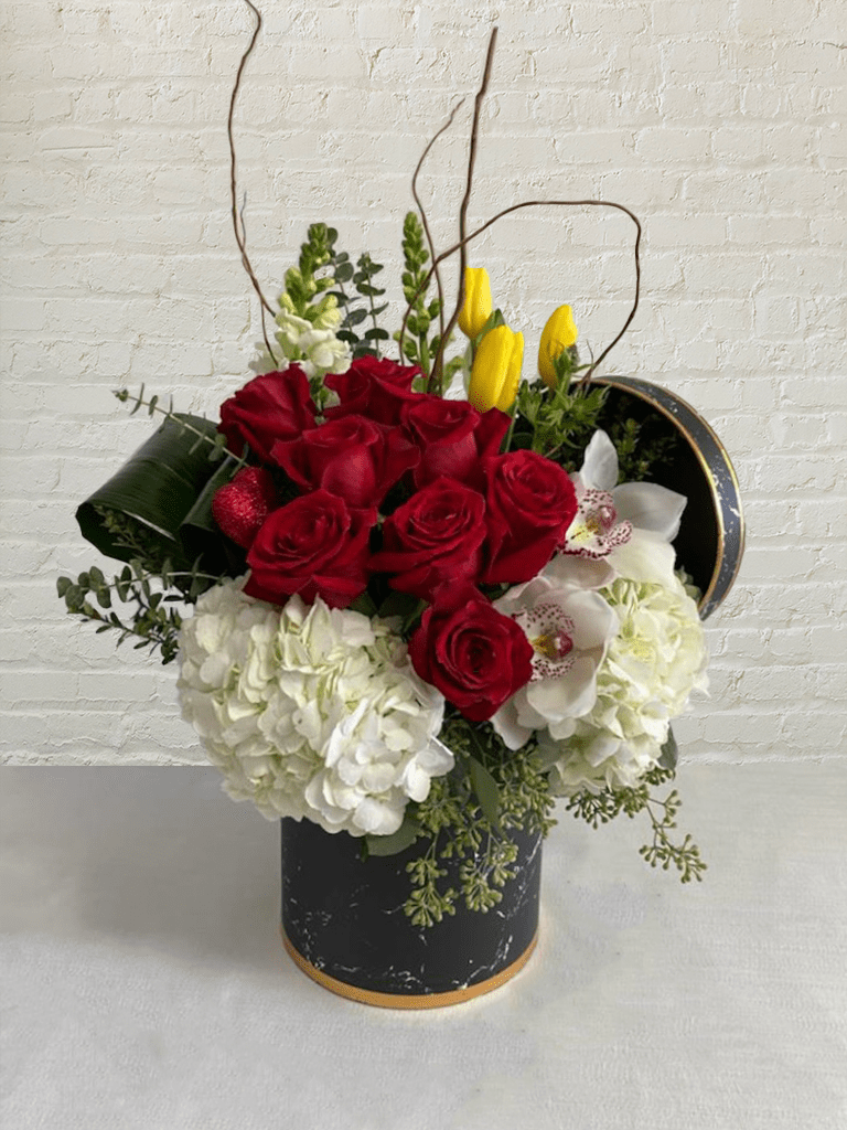 Lady in Red - Medium - Lady in Red is a stunning arrangement by our expert florists, true to life, and designed to add elegance to any room or office. The fresh flowers and delicate greens are delivered in a contemporary vase, a stylish finishing touch that's perfect for any occasion. Abundant 8 roses in a magnificent mixed bouquet with unique seasonal blooms express the designer's signature style. Lady in Red is a timeless gift for any occasion.