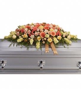 Warmest Remembrance Casket Spray Warmest Remembrance Casket Spray - This tastefully colorful casket spray is not only a tribute to a lost loved one, but a reminder of the many joyous times spent together. The beautiful bouquet includes peach roses, light pink spray roses, coral spray roses, light orange gerberas, light orange carnations, light yellow stock and peach hypericum, accented with satin ribbon and assorted greenery. Approximately 50" W x 17 1/2" H Orientation: N/A