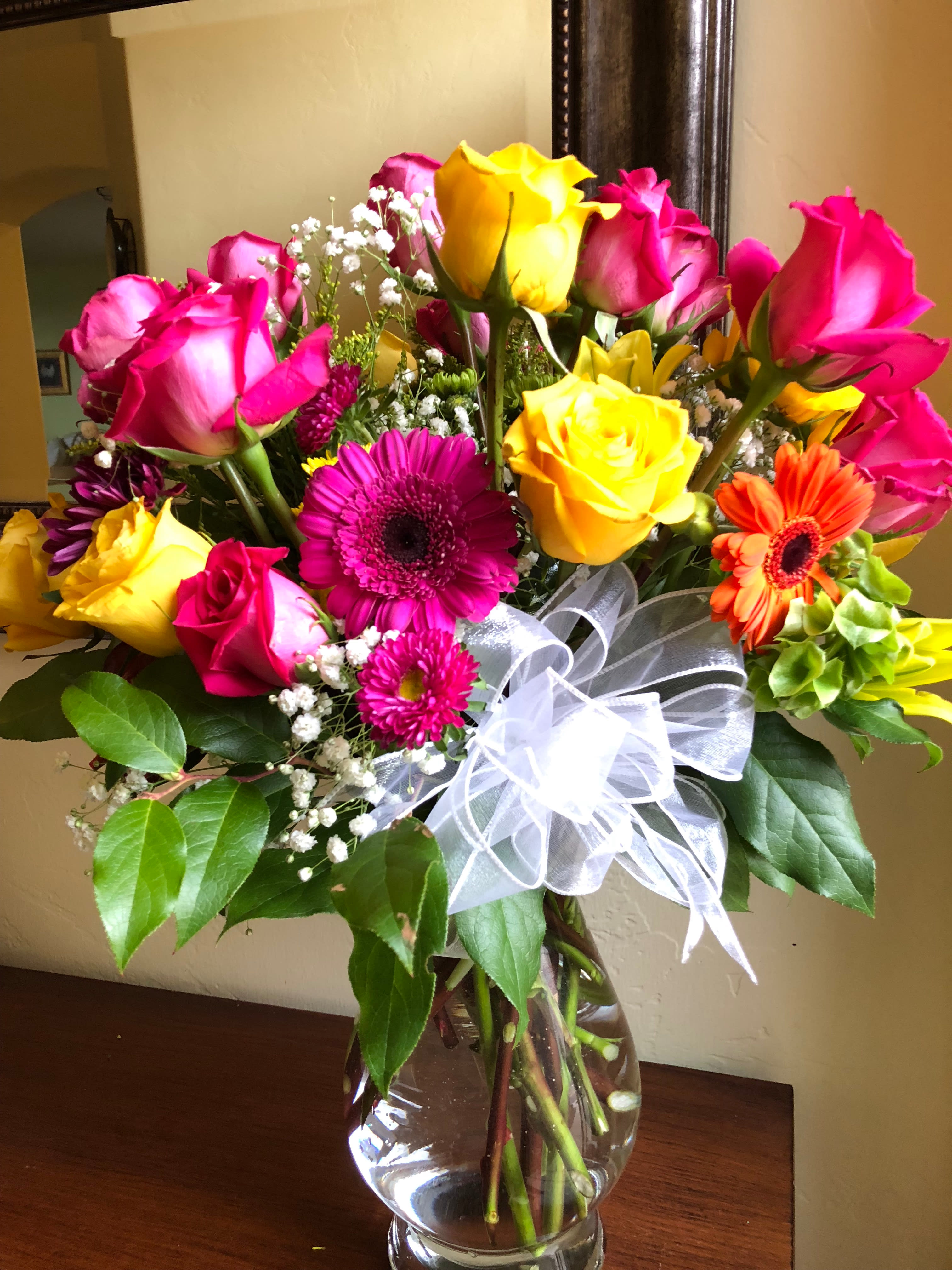 Renee's Rainbow Renee's Rainbow - Fill someone's home or office with this vase that is brimming over with bright gerbera daisies, yellow and hot pink roses nestled in some vibrant greenery! Great for get-well, birthdays and general uplifting bouquet for you or someone you care for.