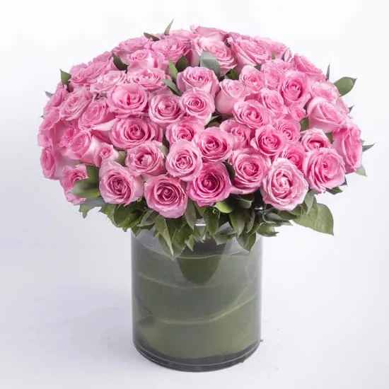 Pink Paradise Bouquet - A beautiful and luxurious bouquet of 50 fresh premium pink roses arranged in a stunning vase. This romantic and elegant arrangement is the perfect way to express your love and appreciation for someone special on Valentine's Day or any day. The vibrant pink color and the sweet fragrance of the roses will bring a smile to their face and brighten up any room. Surprise your loved one with this luxurious and enchanting bouquet today.