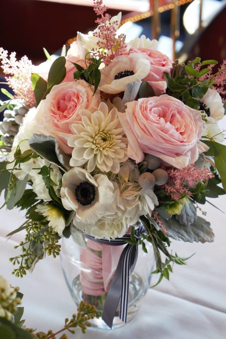 Bridal Bouquet 1 Bridal Bouquet 1 - Soft pink garden roses, white anenomes, miniature cream dahlias, astilbe, ferns, berzillia and other natural garden accents. Wrapped in satin of your choice. All prices subject to change based on seasonality. **It is always best to make a consultation appt. for a full wedding quote** NOT AVAILABLE FOR SAME DAY DELIVERY- THIS IS A PREBOOKED ITEM ONLY **