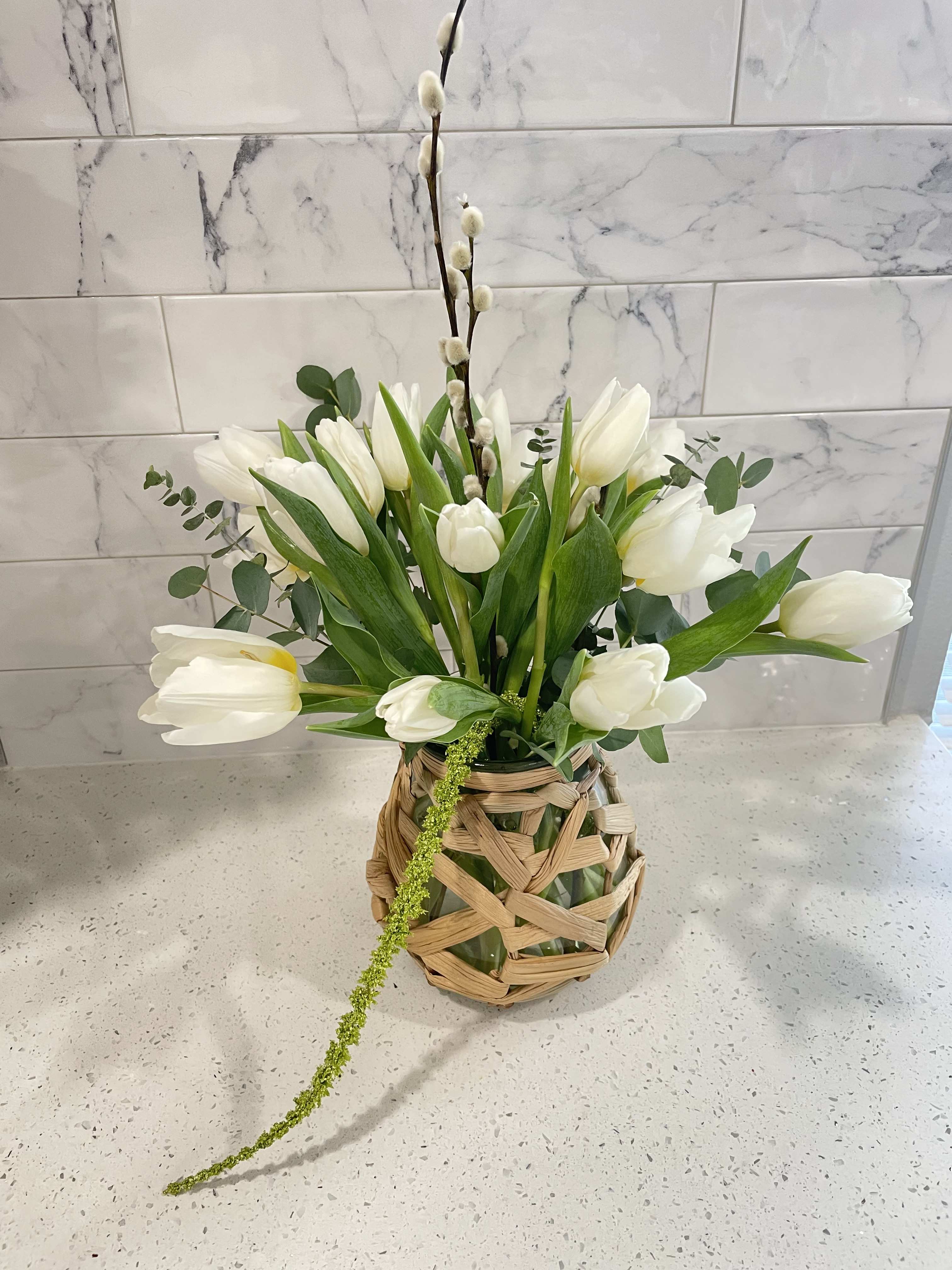 Tranquil Tulip  - People spend lifetimes searching for inner peace. We’re not going to say the Tranquil Tulip arrangement will lead you immediately there. But, on the other hand, who wouldn’t want a bit of tulip comfort on their meandering path to lifelong serenity. Gift this arrangement to someone who deserves a bit of tranquility in their life this holiday season. VASE MAY VARY DUE TO SHORTAGES  Each bloom is privately selected and chosen for each arrangement for quality control as well as having hydro dip solution for each stem for guaranteed freshness and hydration.