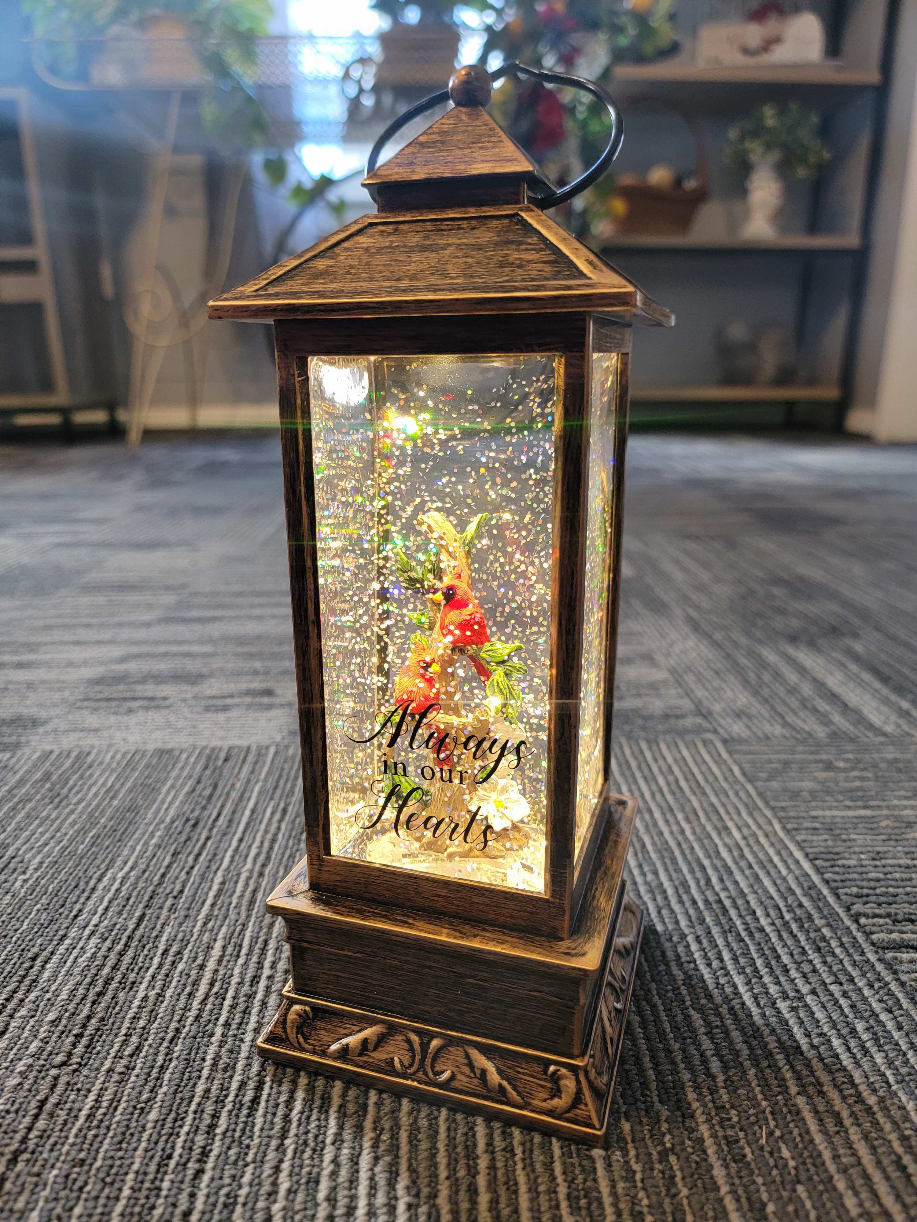 &quot;Cardinals&quot; Water Glitter Lantern - &quot;Always in Our Hearts&quot; Glittern Lantern Our water glitter lanterns are designed with quality and sentiment in mind. The high-quality polyresin lantern features a built-in light and circulator for swirling glitter. The light also features an automatic timer that turns the light on for 6hrs and back off for 18hrs. The lantern will come with AAA batteries and we will add a bow and card for personalization. The lantern is about 12 inches tall.