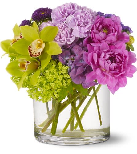 Watercolor Beauty - All the delicate tones of a watercolor painting, captured in an ethereal bouquet. Green orchids and purple dahlias mingle with lavender and chartreuse blooms to create a vision of pure beauty.   Green cymbidium orchids and viburnum, purple dahlias, hydrangea and Matsumoto asters and lavender carnations â accented with seafoam statice â are arranged in a cylindrical clear glass vase. Approximately 11&quot; (W) x 11.25&quot; (H) 