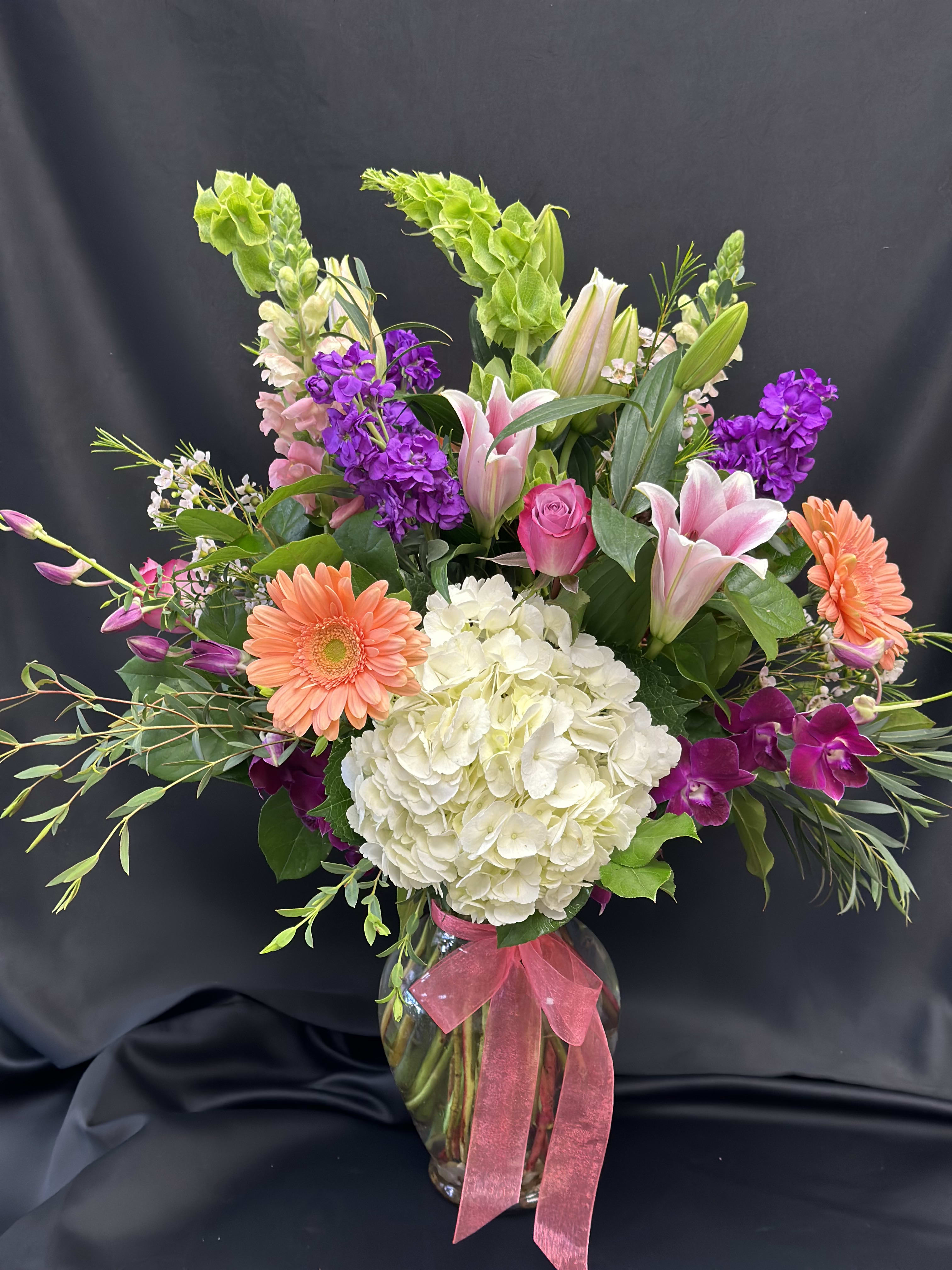Lush &amp; Lovely - A stunning mix of seasonal favorites  - always a show stopper! Fragrant stargazer lilies, bells of Ireland, hydrangea, stock, snapdragons and roses.  