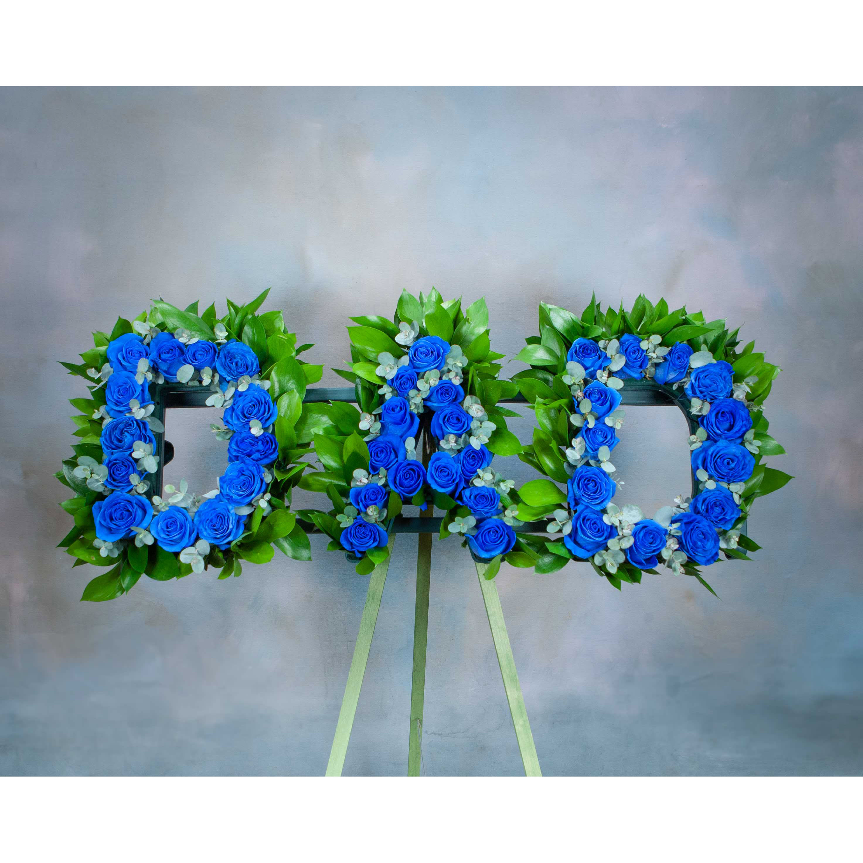 Letter &quot;DAD&quot; Standing Spray -  (SF703) - This sympathy standing spray, in the color blue, is a stunning symbol of your sympathy and support. This arrangement can be customized to say whatever name or title needed for your loved one.   In this arrangement: - Stem-dyed blue roses  Dimensions: - The overall TOTAL letters length is 32 inches wide - Each letter is approximately 11 inches tall, and 8.5 inches wide  Please note: In order to ensure we have the flowers needed in stock, please pre-order at least a week in advance.  DELIVERY DISCLAIMER: Due to availability of stem-dyed blue roses in surrounding areas, this arrangement CANNOT BE SENT OUTSIDE OF OUR LOCAL IN STATE DELIVERY AREA. Please call our store if you have any questions. We apologize for any inconvenience.