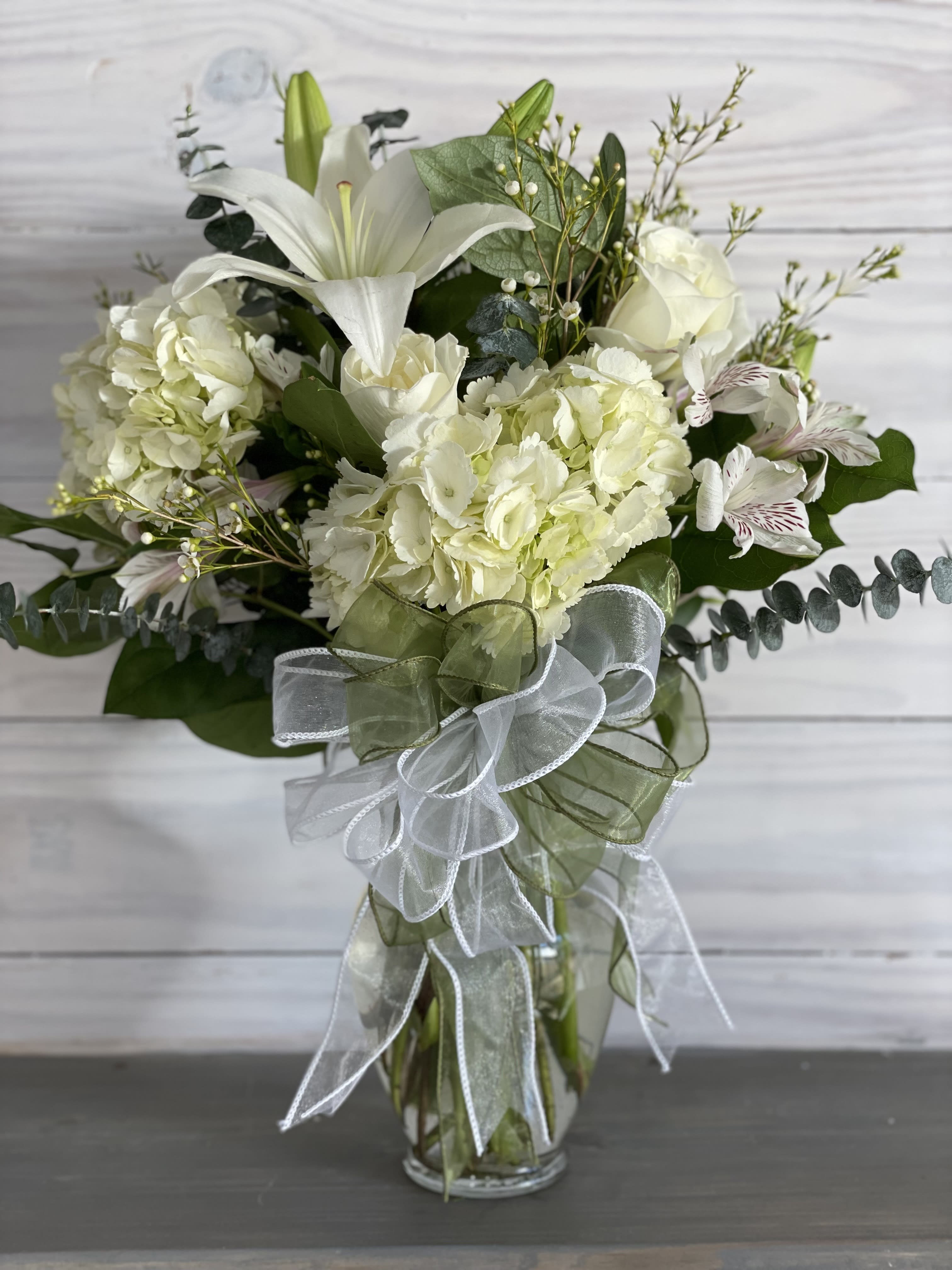 Pure Heart - This is an elegant all white arrangement of blooms in a vase.  A beautiful way to say you care. ****We will try our best to match the flowers in the picture, but there may be times when we substitute flowers. We will always try to make it have the same look and feel as the original.