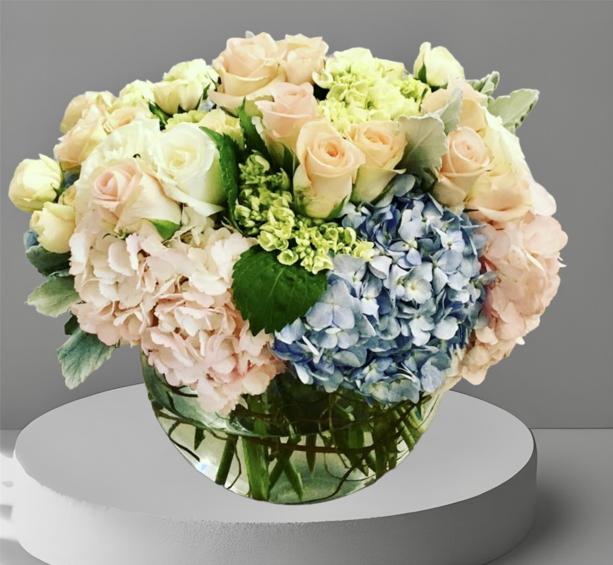 A Beautiful Bowl - A gorgeous mix of pastel hydrangea and roses with seasonal foliage arranged is a large glass bowl. Perfect as a welcome baby gift, thank you gift, or just because.