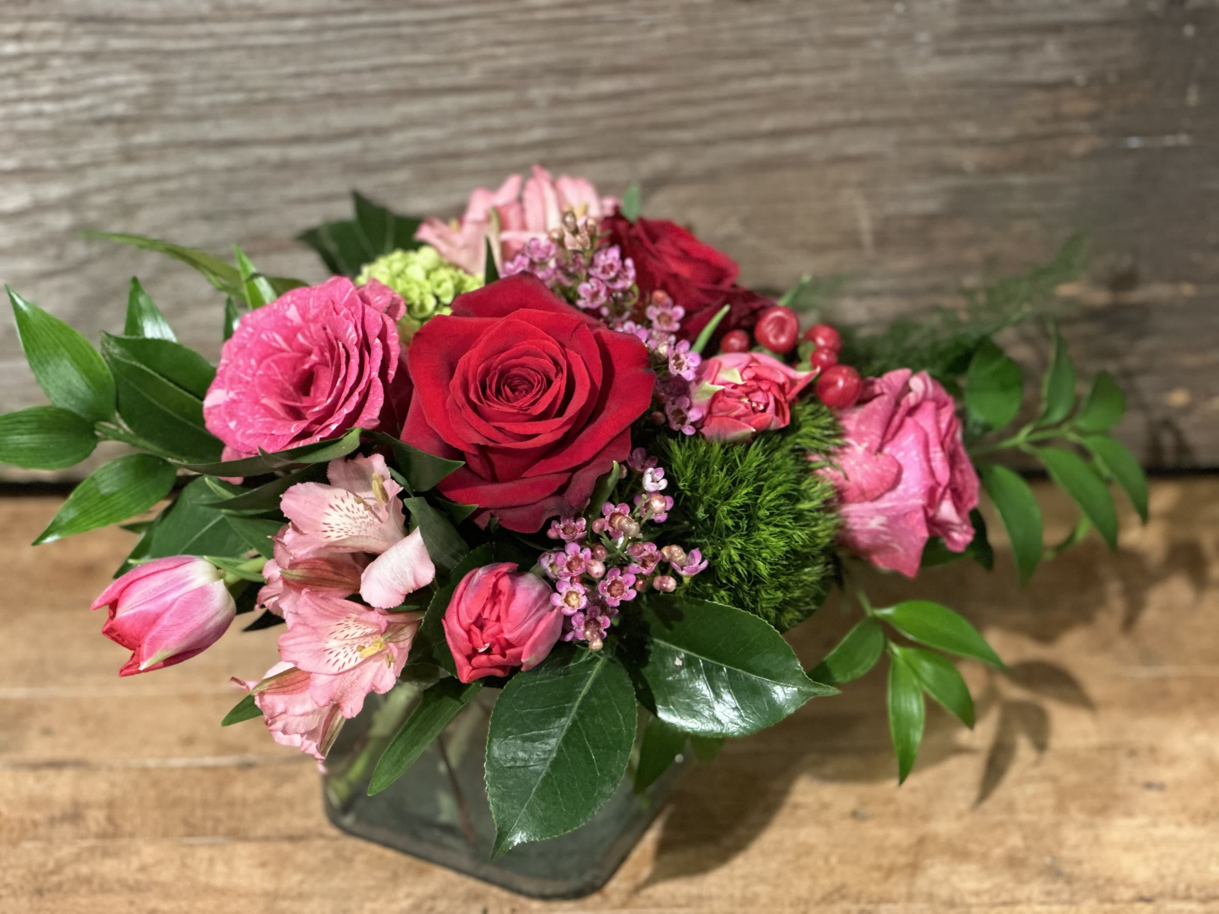 Love Is In The Air Love Is In The Air - Lucious pinks and reds, featuring distinctive rose varieties, in a square vase. Show your one and only how true your love is!