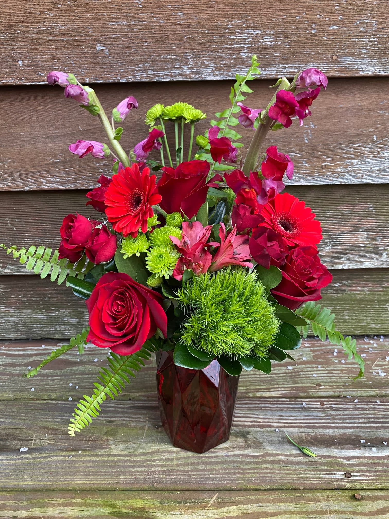 Monochromatic Reds  - For this selection, we fill this 7&quot; red glass geometric vase with assorted red flowers like roses, spray roses, snapdragons, mini gerbera &amp; alstromeria, accented with pops of bright green for some contrast! Please review our substitution policy below. If any flowers are not available, similar flower substitutions will be made to equal or greater value. 