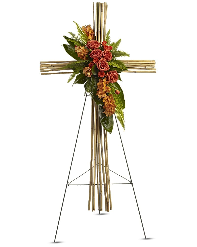 Tropical Remembrance  - This beautiful bamboo cross displays a bright assortment of bright orange topical flowers.  This arrangement features: roses, spray roses, orchids, sword ferns and ti leaves.  *Please note that our easels come on wooden one instead of wire.*