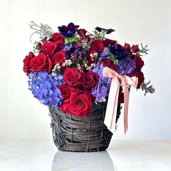 Love In The Basket - The Love In The Basket arrangement is an amazing display of vibrant flowers. Bound together in a large willow basket, this beautiful arrangement features an abundant assortment of flowers including roses, . spray roses hydrangeas, and anemones. This luxury  flower design is sure to brighten any room.