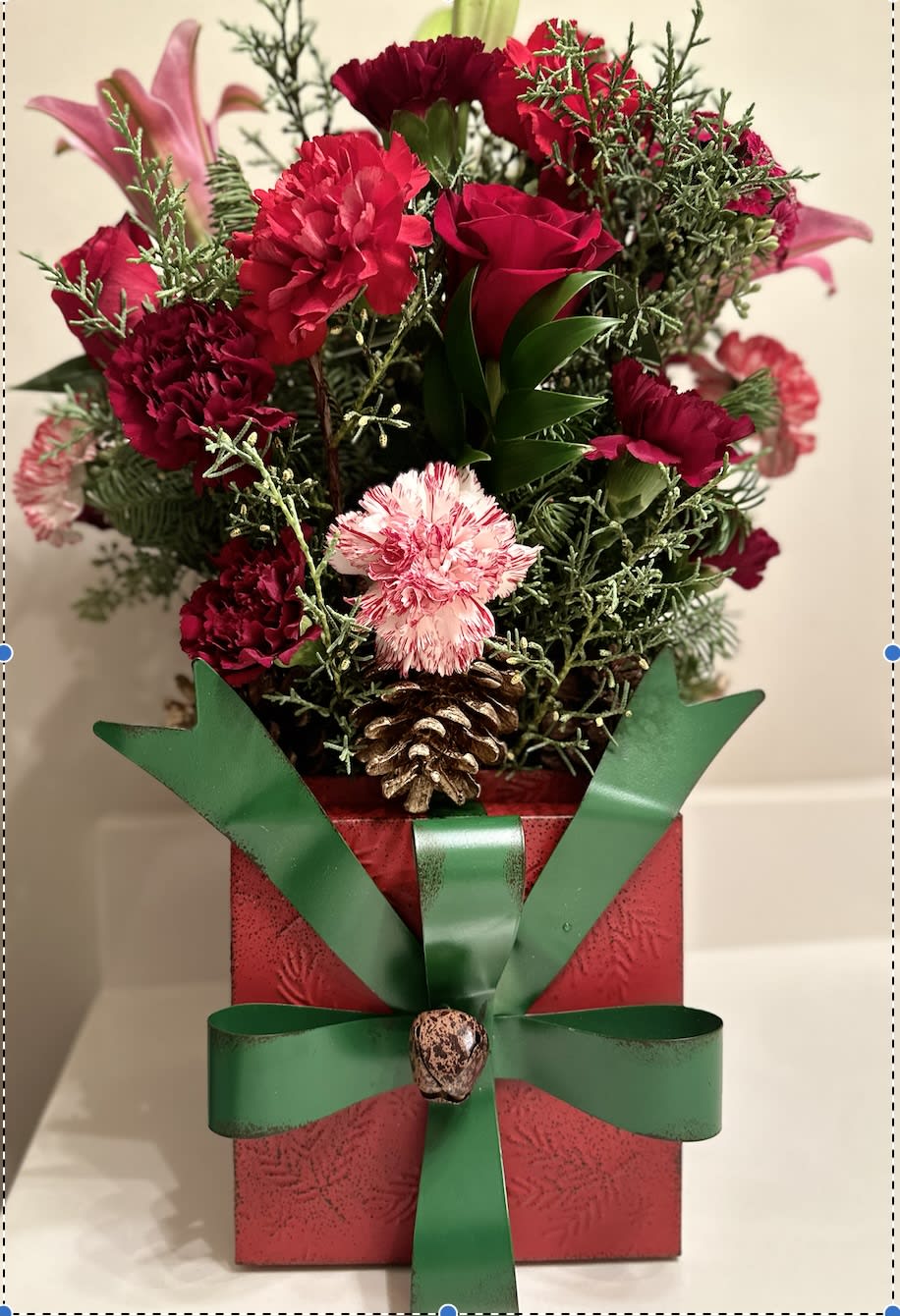 Holiday Centerpiece - Capture the magic of the holidays with this colorful center piece of red roses, pink lilies, and peppermint  carnations make the perfect arrangement that smells like Christmas.