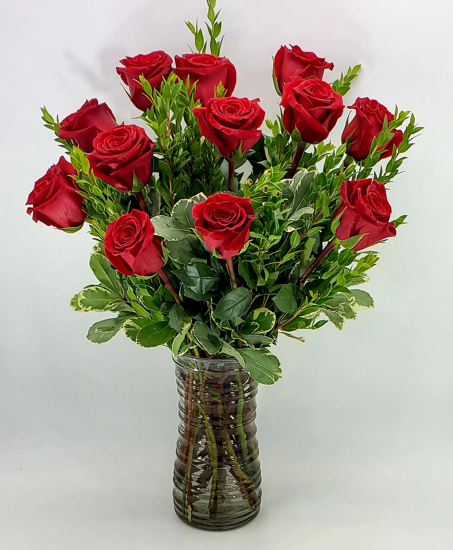 Red Roses And Love - One dozen rich red Rose's warms the heart for all. Choose deluxe category to add fragrant waxflower to your roses. Approximately 24 inches tall. 