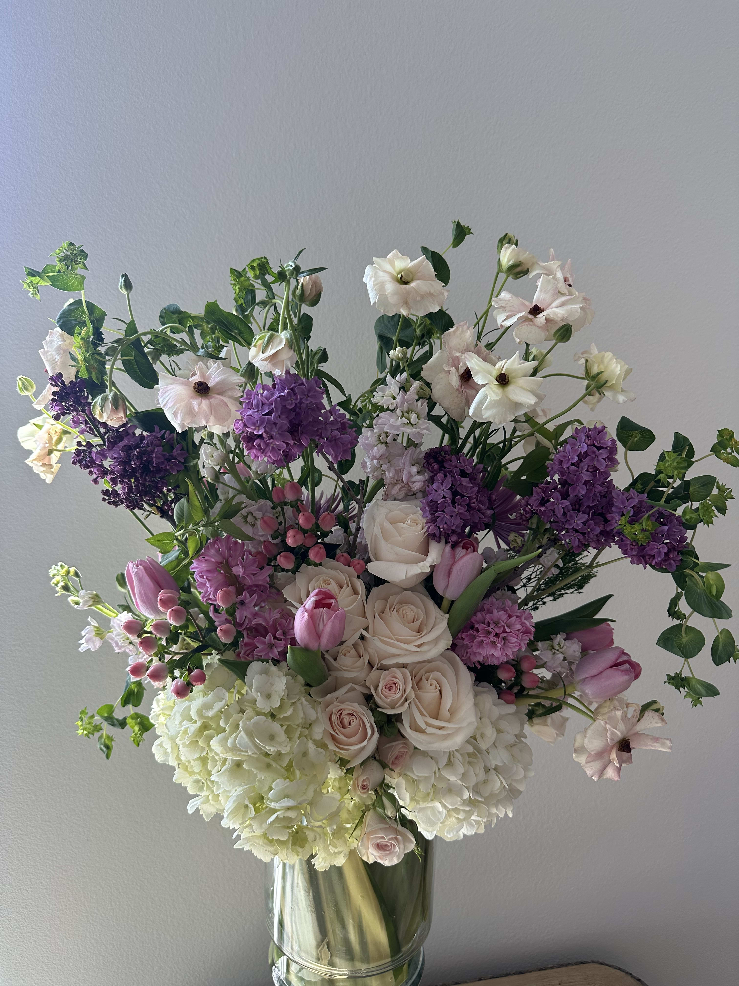 pink diamond - A combination of purple lilac, pink hyacinth, lavender stocks, light pink spray roses, and a bed of white hydrangeas.